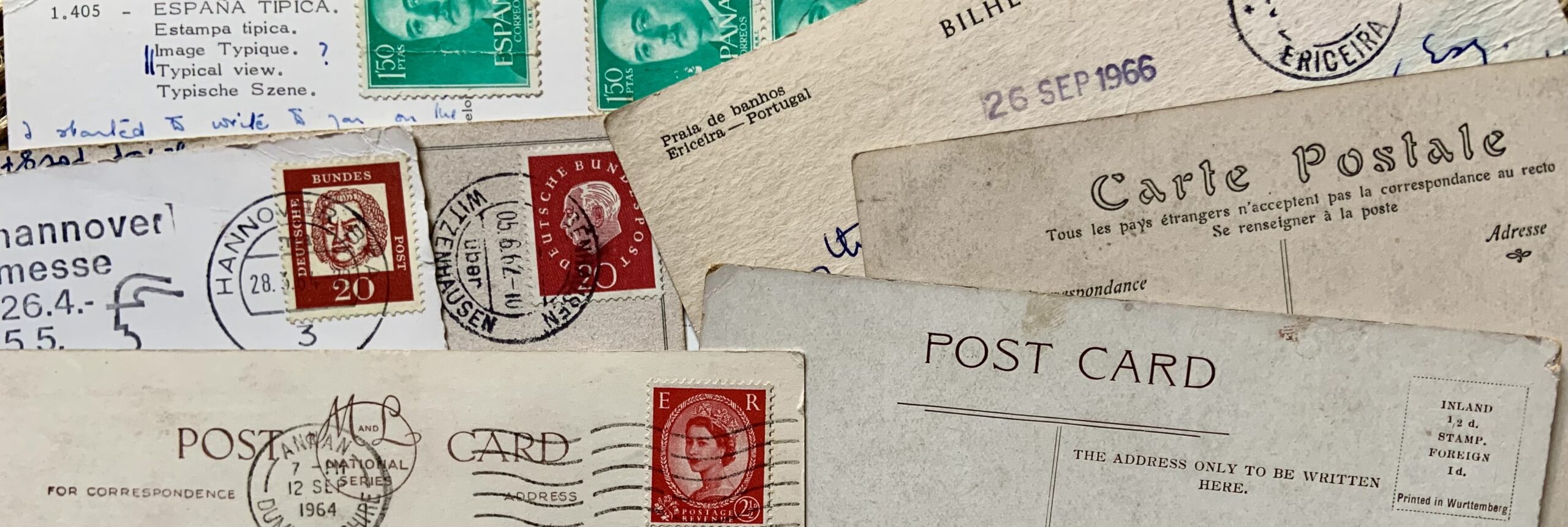 An assortment of vintage postcards showing stamps and postmarks from Spain, Portugal, France, UK and Germany.