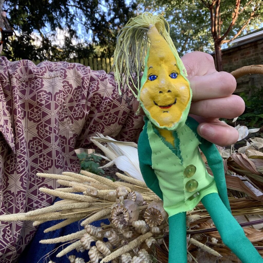 A small yellow-faced puppet held in a white person's hands